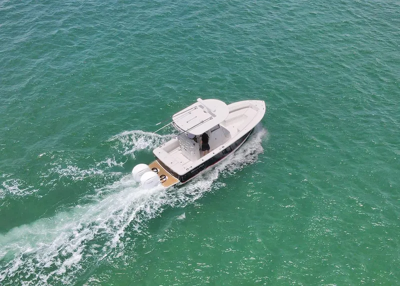 Slide: The Image of 2024 Regulator 23 boat cruising on clear turquoise water, aerial view. - 37