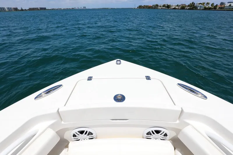 Slide: The Image of 2024 Regulator 23 boat bow on open water, clear sky, coastal view. - 6