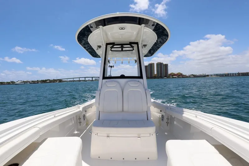 Slide: The Image of 2024 Regulator 23 boat on water, clear sky, bridge and buildings in background. - 9