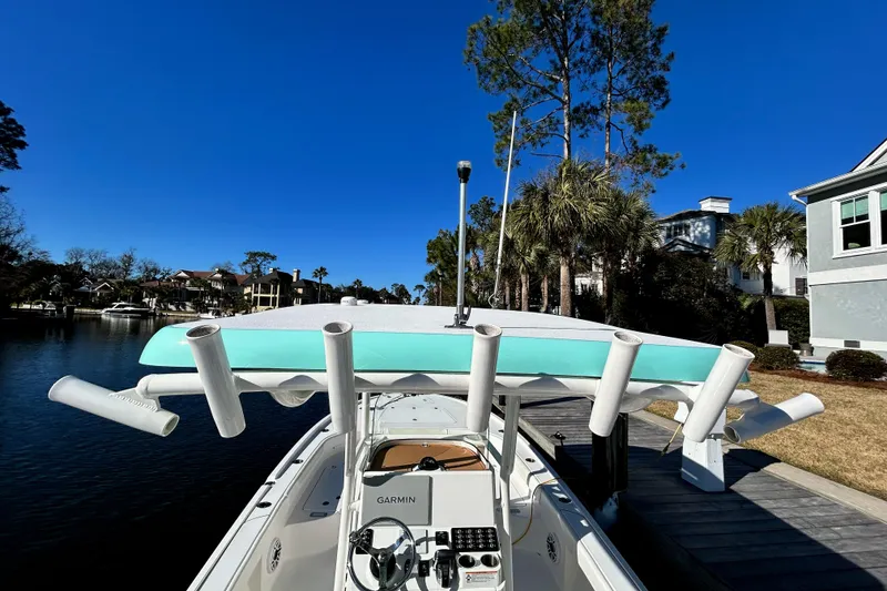 Slide: The Image of 2021 Caymas 28 HB boat docked, featuring rod holders and a Garmin system. - 12