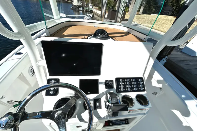 Slide: The Image of 2021 Caymas 28 HB boat dashboard with steering wheel, controls, and display screens. - 22