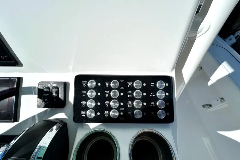 Slide: The Image of Control panel of 2021 Caymas 28 HB boat with switches and cup holders. - 25