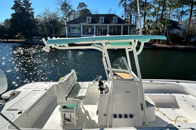 Slide: The Image of 2021 Caymas 28 HB boat on a sunny lake, with a house in the background. - 6