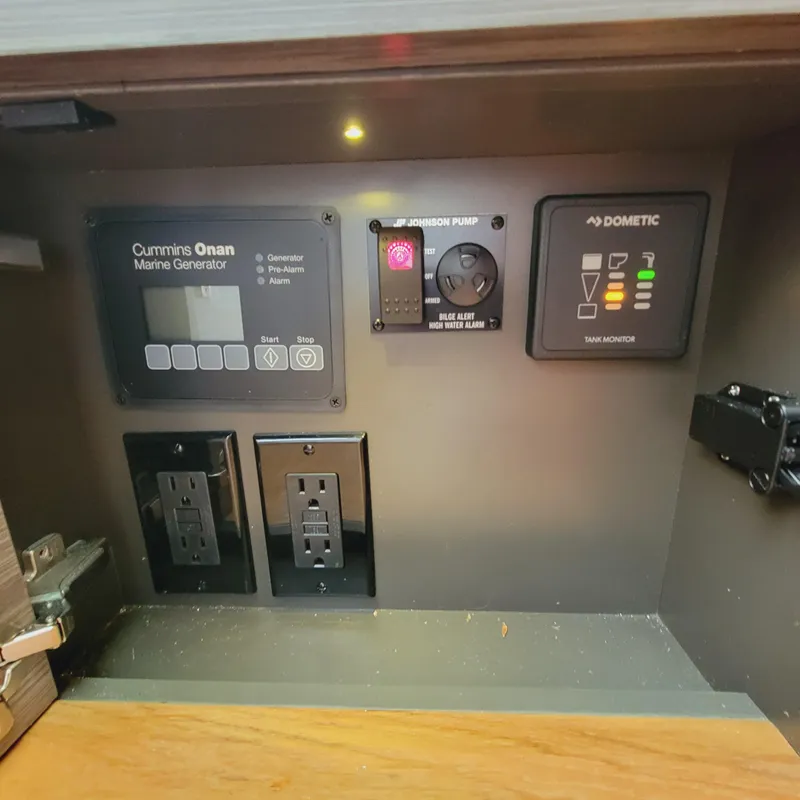 Slide: The Image of Control panel inside 2021 Tiara Yachts 38 LS, featuring Cummins Onan Marine Generator and outlets. - 39