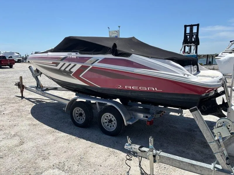 Slide: The Image of 2016 Regal 2000 ESX Bowrider on trailer, covered, parked outdoors under clear blue sky. - 0
