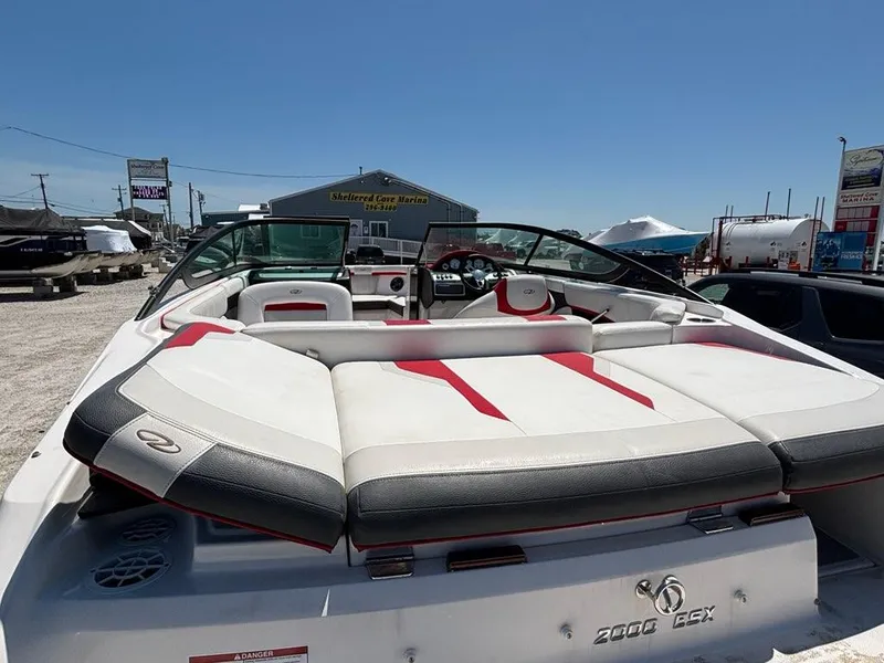 Slide: The Image of 2016 Regal 2000 ESX Bowrider with red and white seating, parked outdoors. - 15