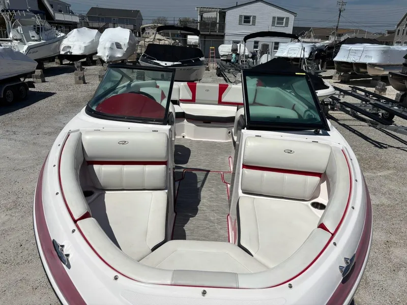 Slide: The Image of 2016 Regal 2000 ESX Bowrider boat with white and red interior, parked outdoors. - 4