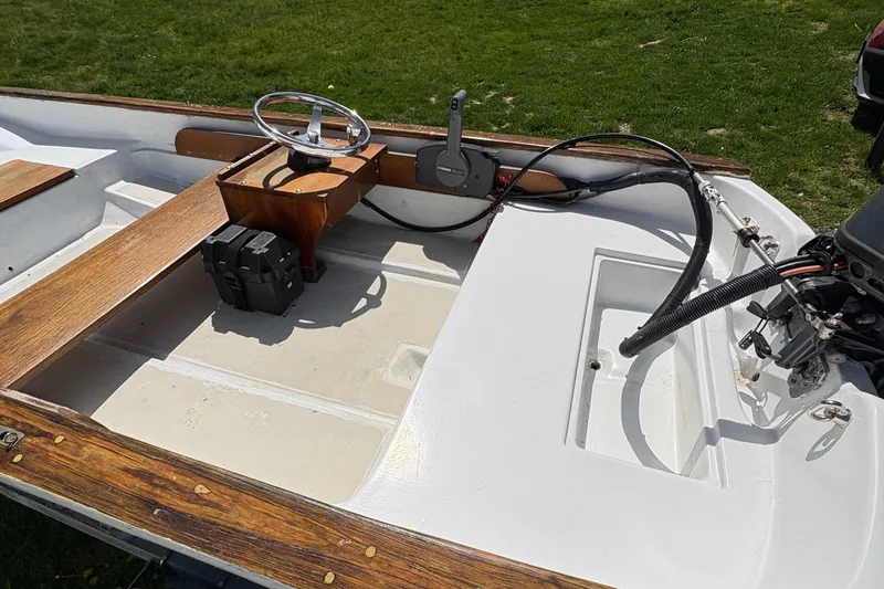 Slide: The Image of 1984 Boston Whaler 11 boat interior with wooden accents and steering wheel. - 5