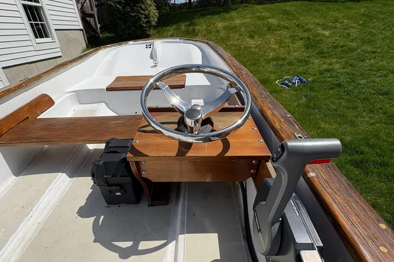 Slide: The Image of 1984 Boston Whaler 11 boat interior with wooden steering console and seating. - 6
