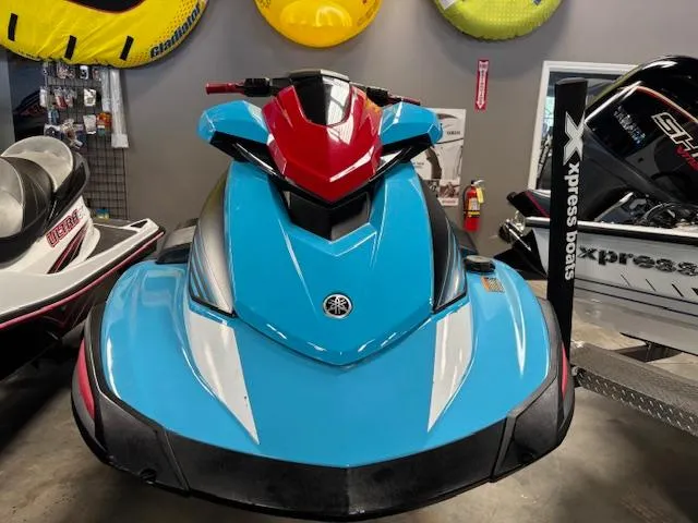 Slide: The Image of 2024 Yamaha WaveRunner VX Deluxe in vibrant blue and red, displayed indoors. - 2