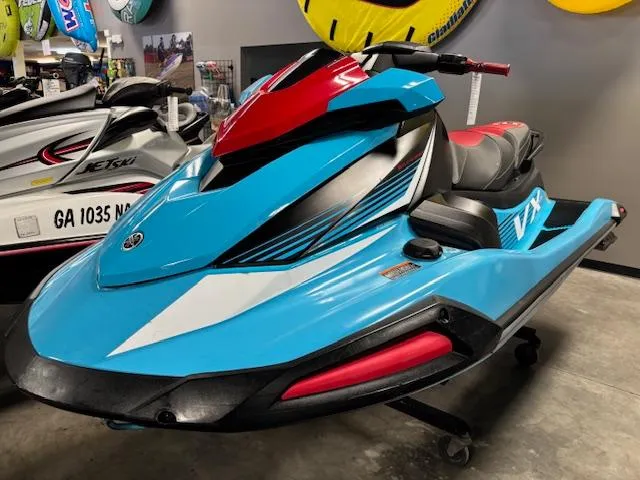 Slide: The Image of 2024 Yamaha WaveRunner VX Deluxe in vibrant blue and red, displayed indoors. - 3