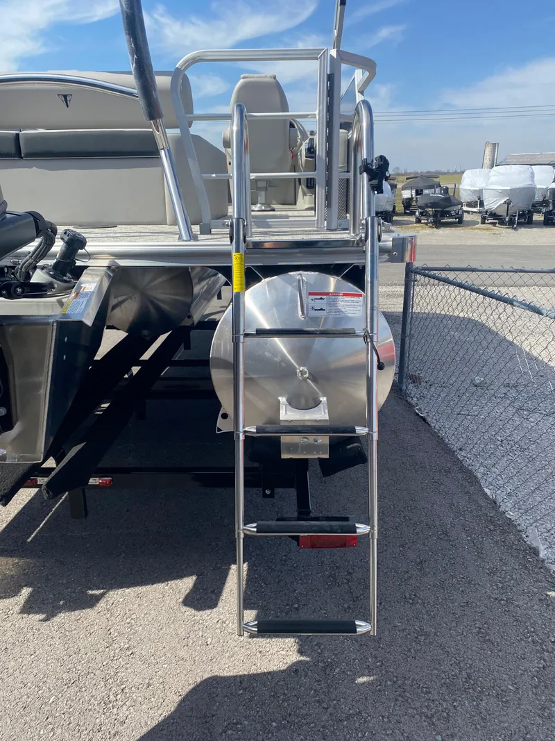 Slide: The Image of 2025 Trifecta LE Series 22UL boat ladder and rear view in a marina setting. - 7