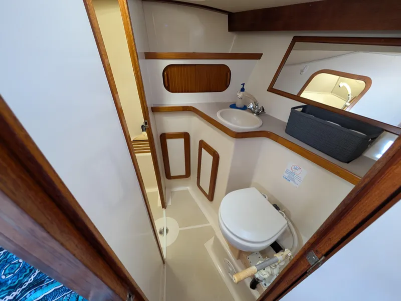 Slide: The Image of Compact bathroom in 1998 Caliber 40 LRC yacht with wooden accents and modern fixtures. - 11