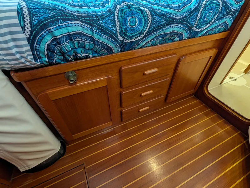 Slide: The Image of Wooden cabin interior with storage drawers and a patterned blue bedspread on a 1998 Caliber 40 LRC. - 12