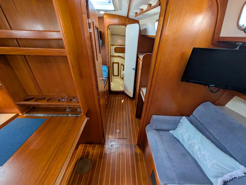 Slide: The Image of Interior of a 1998 Caliber 40 LRC yacht with wooden finishes and cozy seating area. - 14