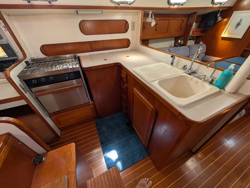 Slide: The Image of 1998 Caliber 40 LRC yacht kitchen with wooden cabinetry, stove, and sink. - 16