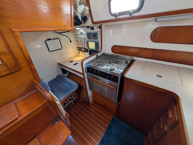 Slide: The Image of 1998 Caliber 40 LRC yacht interior with kitchen, stove, and navigation area. - 20