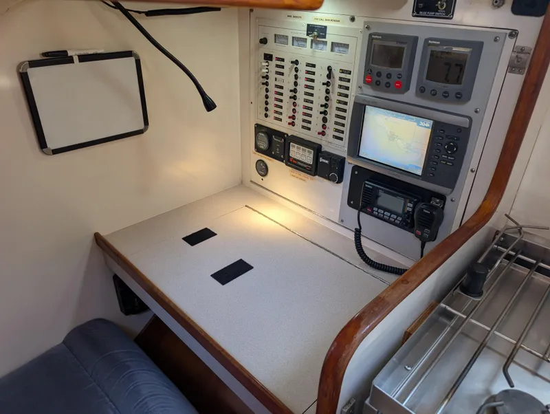 Slide: The Image of Navigation station on a 1998 Caliber 40 LRC yacht with control panels and communication equipment. - 22