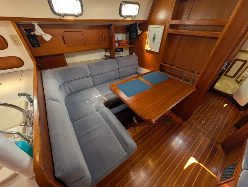 Slide: The Image of 1998 Caliber 40 LRC yacht interior with wooden flooring, cozy seating, and dining table. - 3