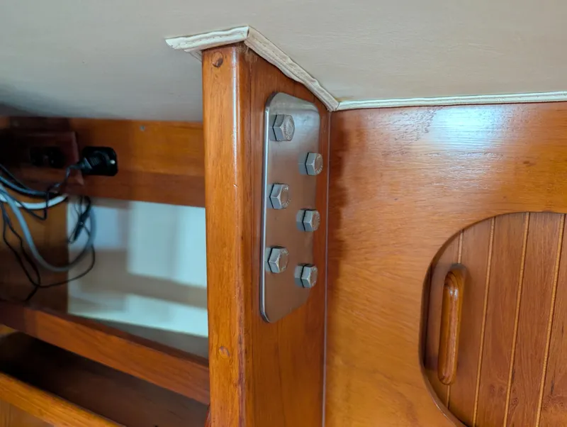 Slide: The Image of Interior detail of 1998 Caliber 40 LRC sailboat, showcasing wooden cabinetry and metal fasteners. - 32