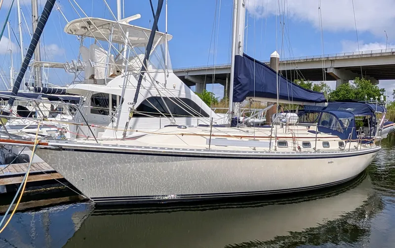 Slide: The Image of 1998 Caliber 40 LRC sailboat docked in marina, featuring sleek design and blue sail cover. - 66