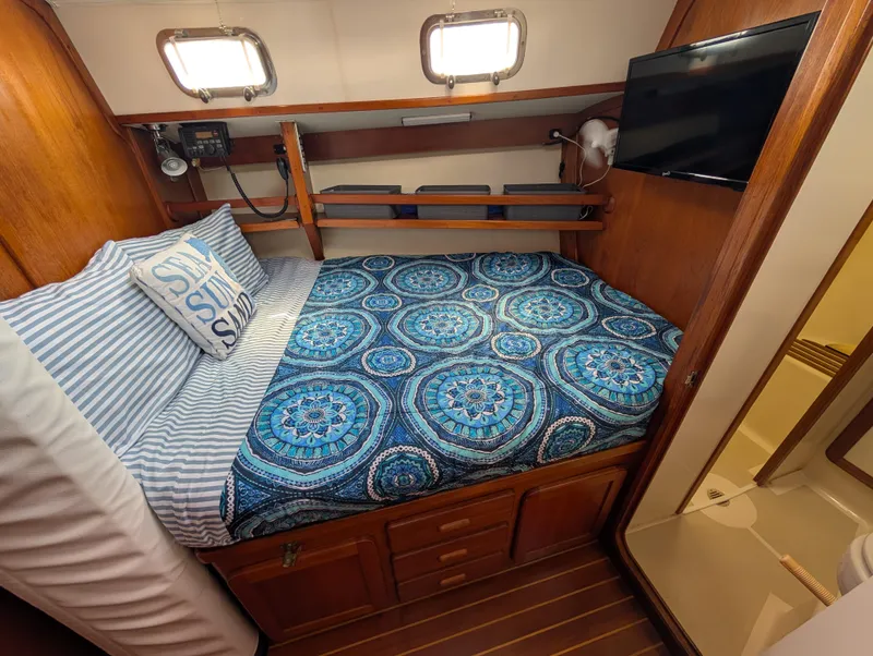 Slide: The Image of Cozy cabin interior of 1998 Caliber 40 LRC sailboat with bed, TV, and nautical decor. - 9