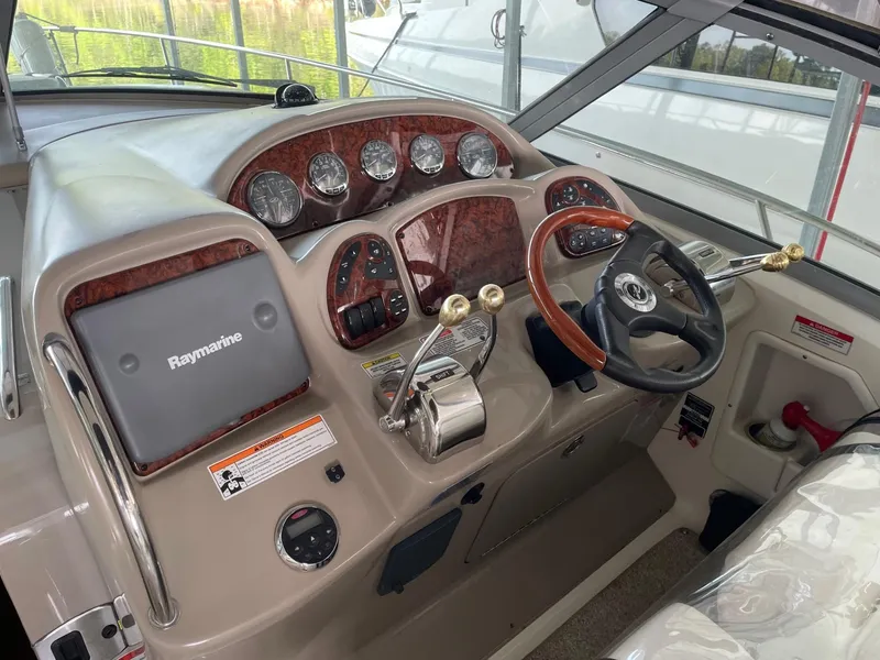 Slide: The Image of 2007 Sea Ray 320 Sundancer helm with Raymarine navigation, wood accents, and modern controls. - 5