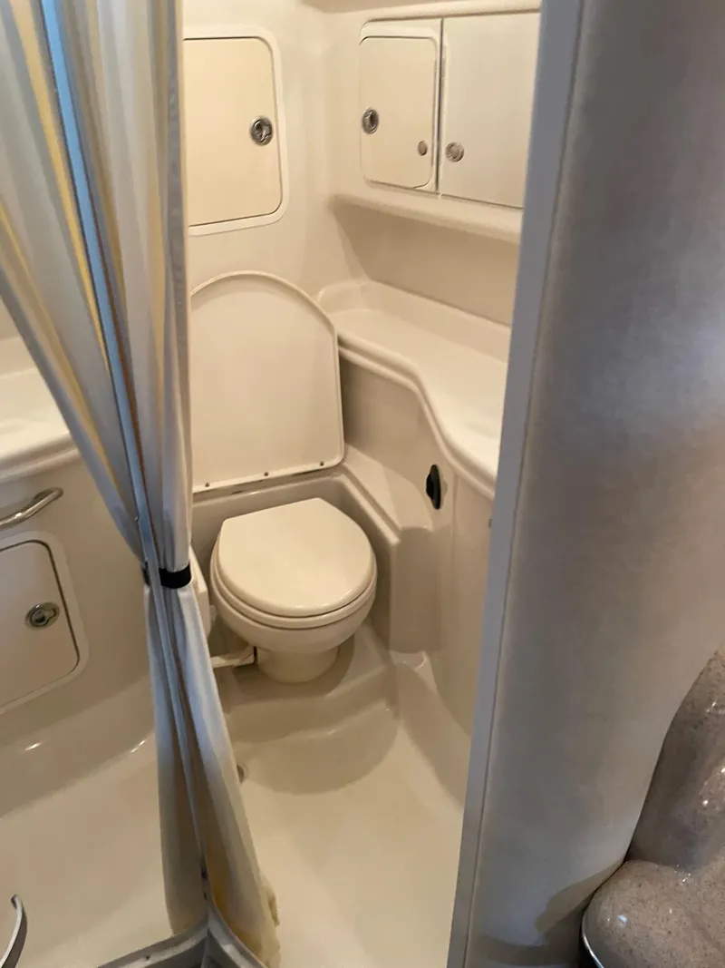 Slide: The Image of 2007 Sea Ray 320 Sundancer bathroom with toilet, shower, and storage cabinets. - 9