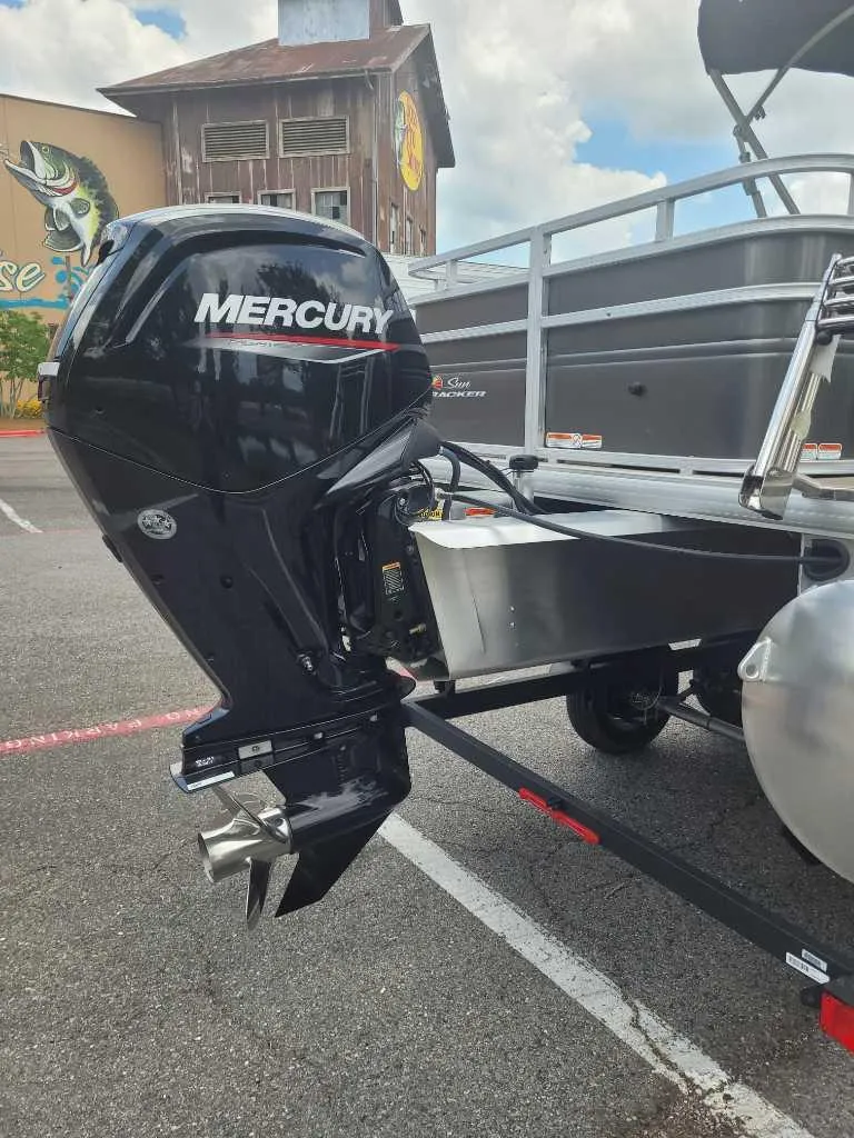 Slide: The Image of 2025 Sun Tracker Fishin' Barge 20 DLX with Mercury outboard motor in parking lot. - 5