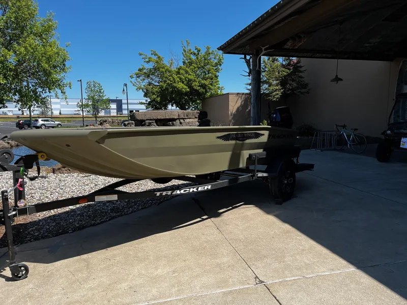 Slide: The Image of 2025 Tracker Grizzly 1650 T Prairie Wings Edition boat on trailer, parked outdoors. - 2