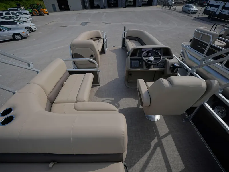 Slide: The Image of 2025 Sun Tracker Party Barge 18 DLX interior with beige seating and steering console. - 5