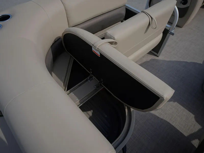 Slide: The Image of 2025 Sun Tracker Party Barge 18 DLX with open storage compartment in beige seating. - 9
