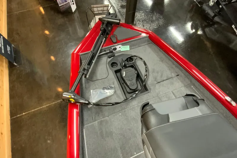Slide: The Image of 2025 Tracker Pro Team 175 boat interior with red trim and trolling motor. - 7