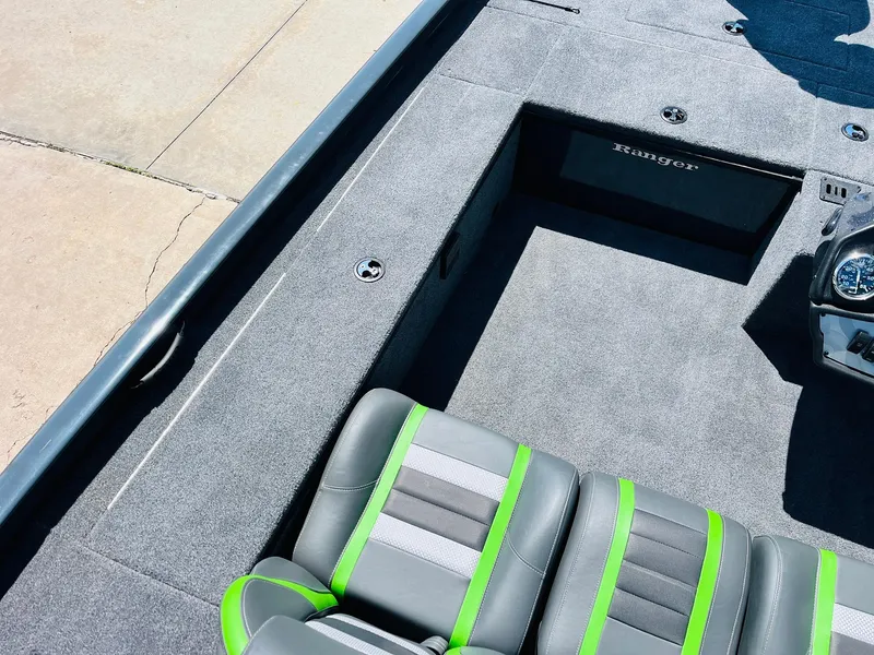 Slide: The Image of 2025 Ranger RT188C boat interior with gray and green seats, spacious deck, and storage compartment. - 31