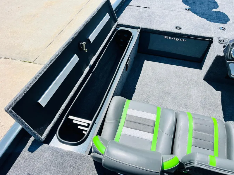 Slide: The Image of 2025 Ranger RT188C boat interior with open storage compartment and gray-green seats. - 32