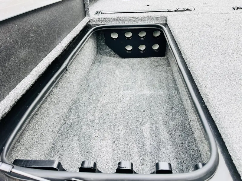Slide: The Image of 2024 Ranger RT198P boat storage compartment with carpeted interior and drainage holes. - 13