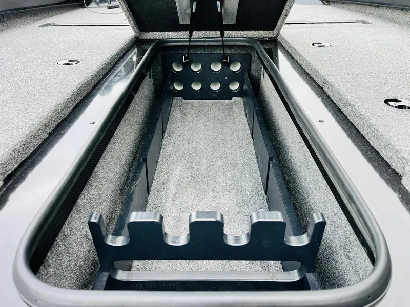 Slide: The Image of 2024 Ranger RT198P boat storage compartment with rod holders and carpeted interior. - 15