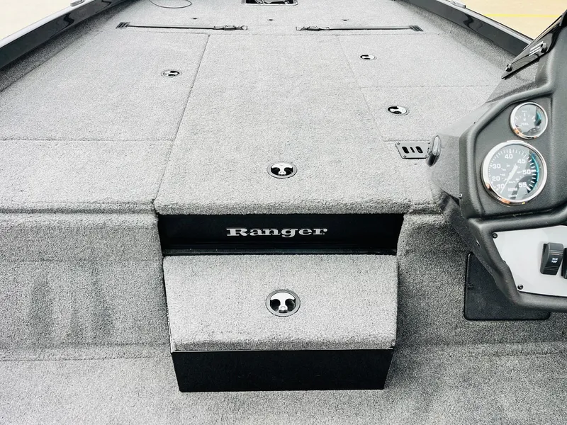 Slide: The Image of 2024 Ranger RT198P boat interior with gray carpet and dashboard controls. - 20