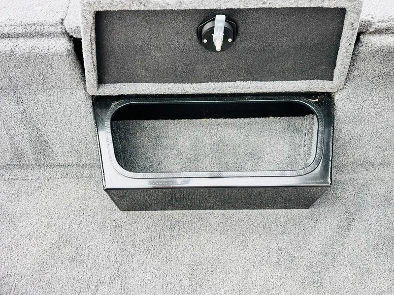 Slide: The Image of 2024 Ranger RT198P boat storage compartment with black trim and gray carpet interior. - 21