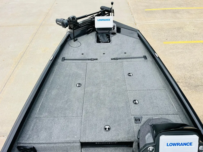Slide: The Image of 2024 Ranger RT198P boat deck with Lowrance electronics, featuring a spacious, carpeted layout. - 9