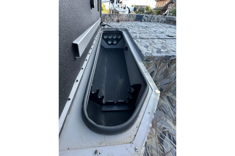Slide: The Image of 2025 Ranger RB200 boat interior with storage compartment and camo-patterned seating. - 98