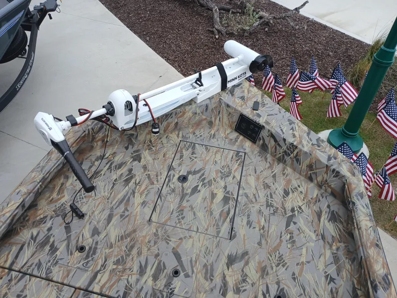 Slide: The Image of 2025 Ranger RB200 boat with camo deck and trolling motor, surrounded by American flags. - 6