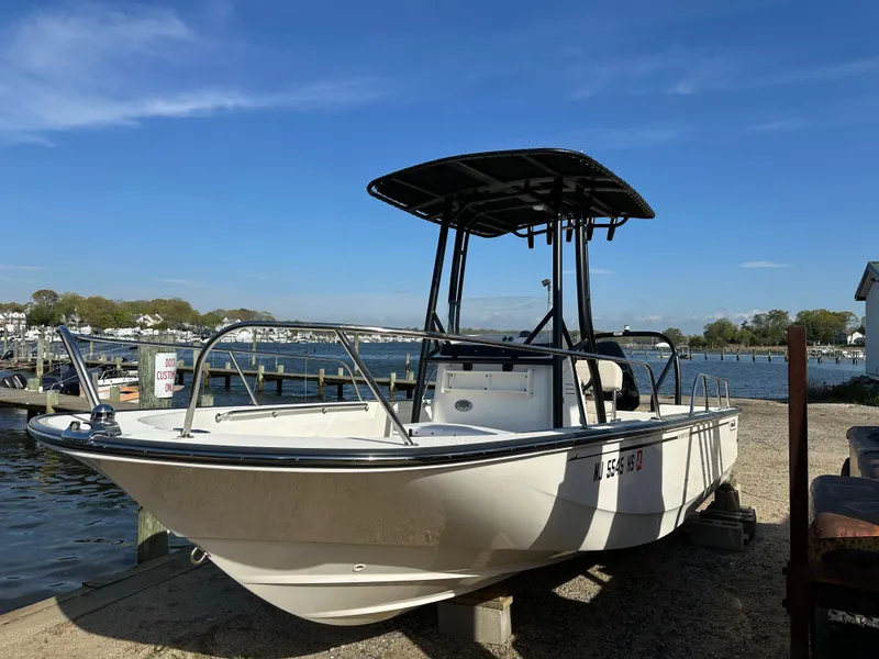 Slide: The Image of 2024 Boston Whaler 190 Montauk boat docked by a scenic waterfront. - 3