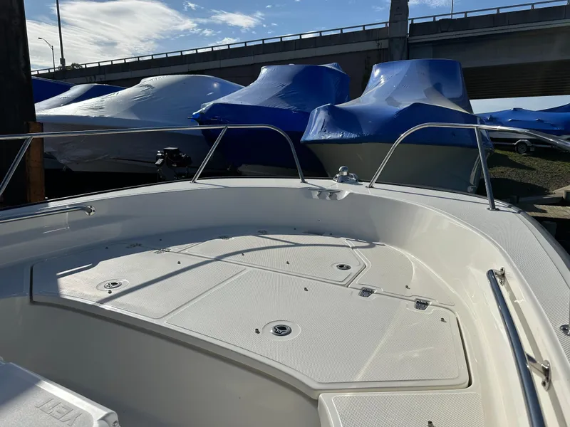 Slide: The Image of 2024 Boston Whaler 190 Montauk boat deck, with covered boats in the background. - 5