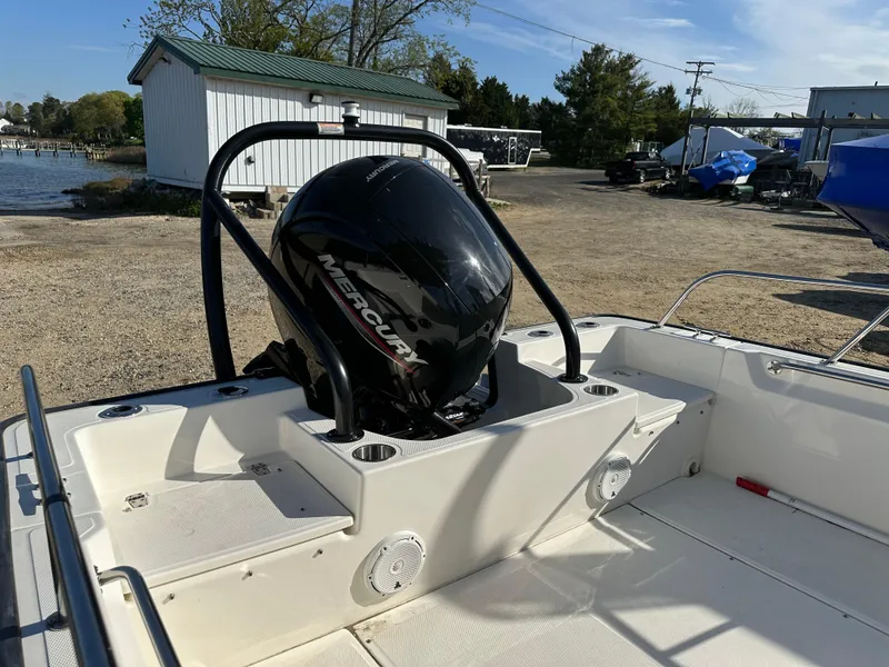 Slide: The Image of 2024 Boston Whaler 190 Montauk boat with Mercury engine, docked outdoors. - 8