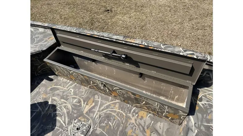 Slide: The Image of Open storage compartment on 2025 War Eagle 750 Gladiator boat with camouflage design. - 2