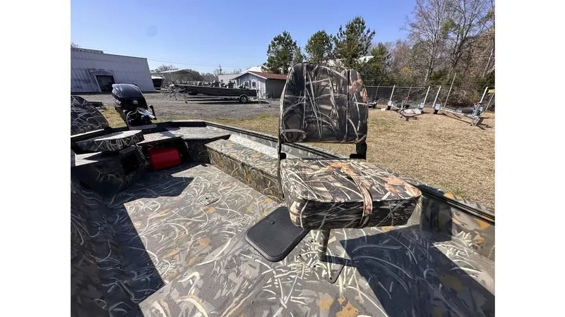Slide: The Image of 2025 War Eagle 750 Gladiator boat with camo seating, outdoor setting, and motor in background. - 6