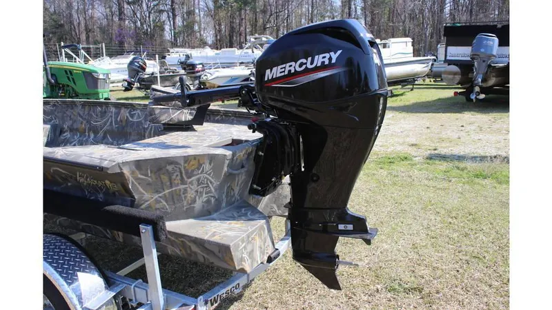 Slide: The Image of 2025 War Eagle 750 Gladiator boat with Mercury outboard motor, parked on grass. - 7