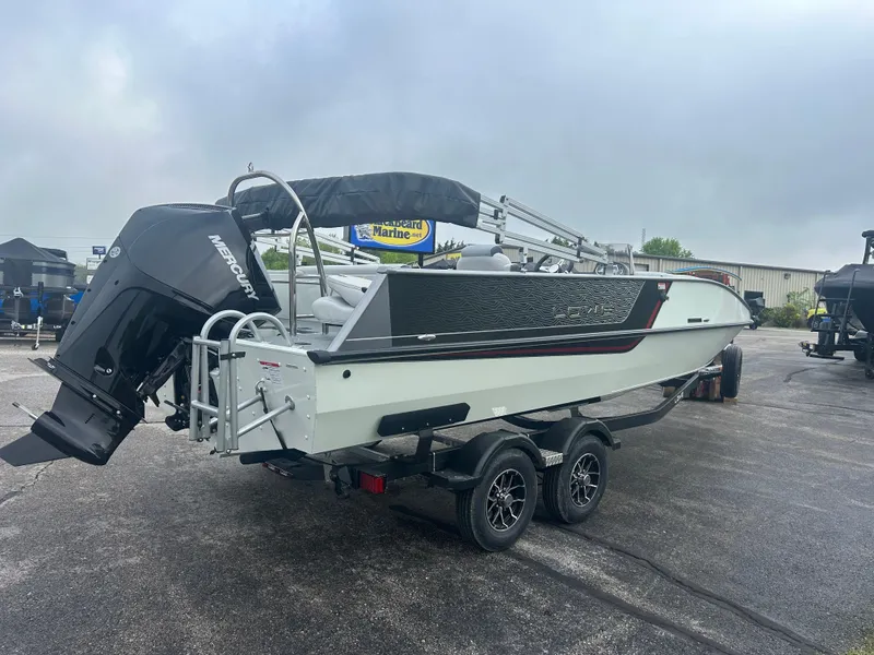 Slide: The Image of 2025 Lowe Deck SD224 boat on trailer with Mercury outboard motor, parked outdoors. - 2