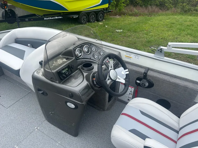 Slide: The Image of 2025 Lowe Deck SD224 boat interior with steering console and seating. - 7